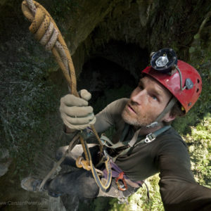 Carsten Peter seilt in einen gro§en Tageslichtschacht in Hang Son Doong